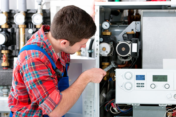 Heating technician repairing boiler controls in Campbell
