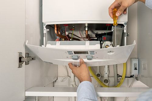 Heating technician repairing a residential boiler in Campbell