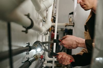 Technician inspecting commercial plumbing pipes in Campbell