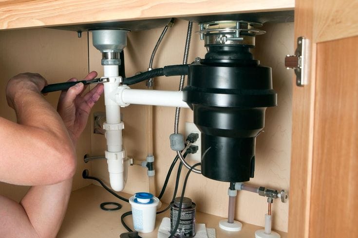 Plumber repairing a garbage disposal in Campbell