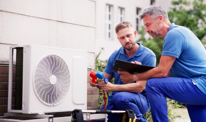 HVAC technicians installing an outdoor air conditioning unit in Campbell